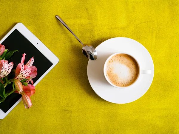 Cup of coffee with tablet on green background — Stock Photo, Image