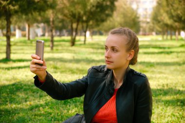 Genç kadın selfie smartphone ile yeşil park yapma