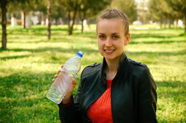 Красивая женщина с пластиковой бутылкой воды — стоковое фото