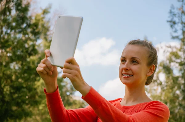 Jovem mulher fazendo selfie com tablet no parque verde — Fotografia de Stock