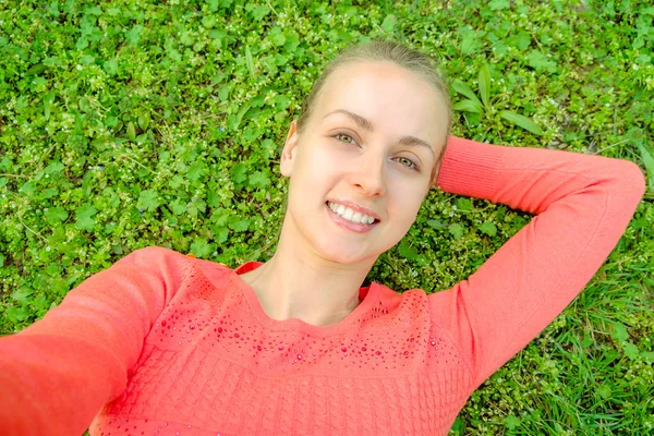 Young woman make selfie in the park on green grass — Stock Photo, Image