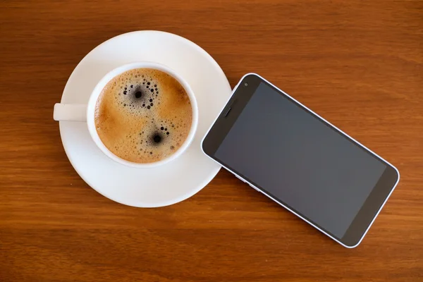 Smartphone with cup of espresso coffee on wooden table — Stock Photo, Image