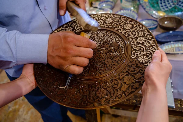 Craftsman carving patterns on the wooden plate — Stock Photo, Image