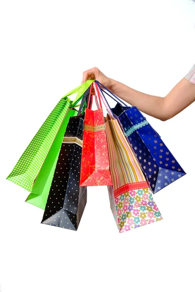 Mano femenina sosteniendo bolsas de compras multicolor — Foto de Stock