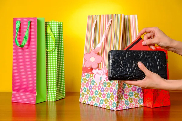 Mujer mano tirando de la tarjeta de crédito de la cartera negro — Foto de Stock