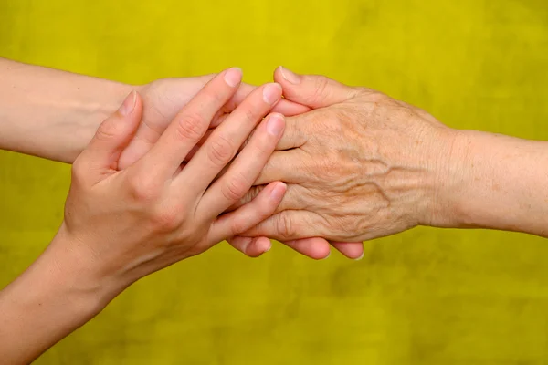 Vieja y joven tomados de la mano — Foto de Stock