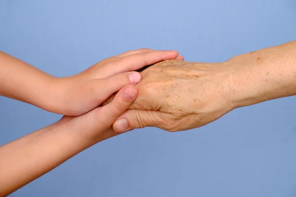 Oude vrouw en meisje hand in hand samen Stockafbeelding