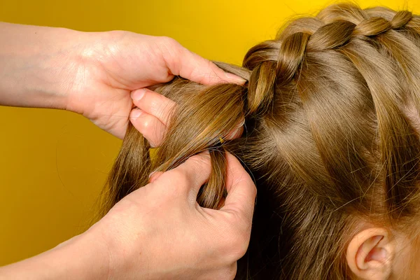 Mother braiding French braid her daughter — Stock Photo, Image