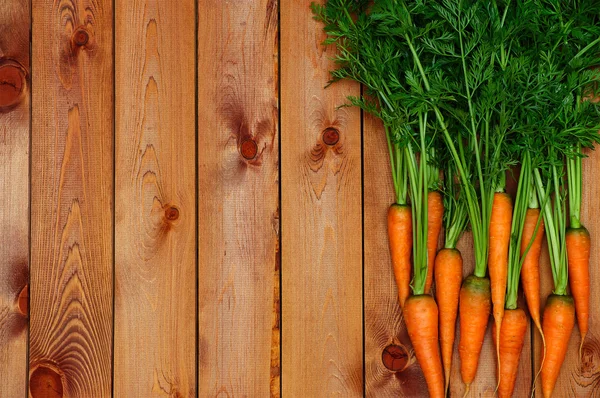 Cenoura laranja fresca sobre fundo de madeira — Fotografia de Stock