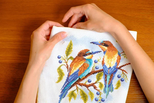 Hands of a young woman embroidering cross picture — Stock Photo, Image