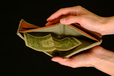 Empty wallet with one dollar on black background clipart