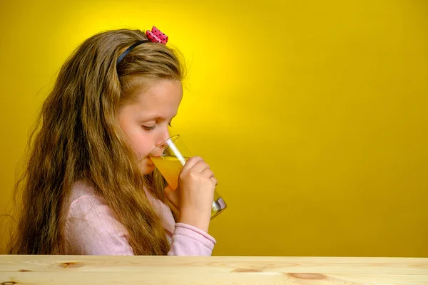 Feliz linda chica sosteniendo un vaso con jugo de naranja — Foto de Stock