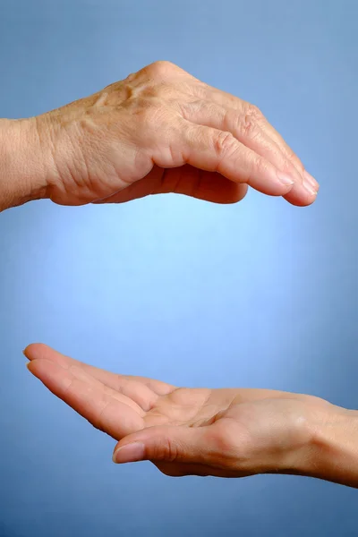 Mano de anciana por encima de la mano de joven — Foto de Stock