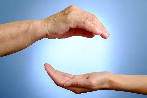 Hand van oudere vrouw boven jonge vrouw hand — Stockfoto