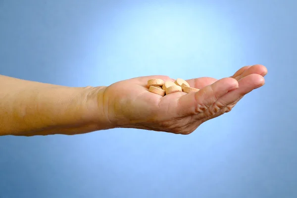 Closeup of senior woman's hand holding medications — Stock Photo, Image