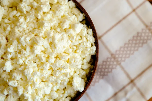 Hüttenkäse in der Holzschüssel auf der Serviette, von oben — Stockfoto