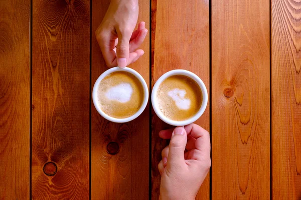Мужчина и женщина держат чашку кофе в кафе — стоковое фото
