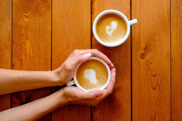 Mulher no café segurando uma xícara de café — Fotografia de Stock