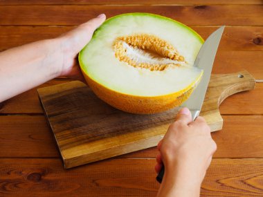 Woman's hand cutting the melon