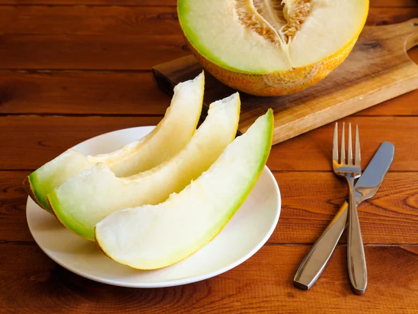 Melone fresco e succoso su uno sfondo di tavolo di legno — Foto Stock