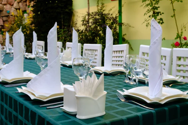 Bicchieri, forchette, coltelli, piatti sul tavolo del ristorante — Foto Stock