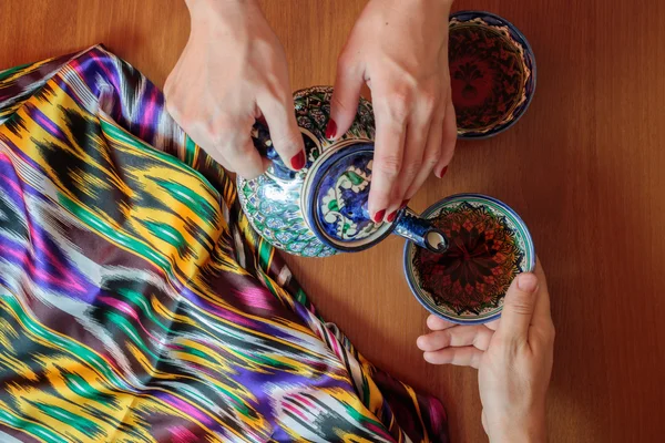 女性は、男性のためのお茶を注ぐ。東洋の伝統、サマルカンド、ウズベキスタン. — ストック写真