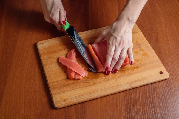 Woman hands slicing trout fish — Stock Photo, Image