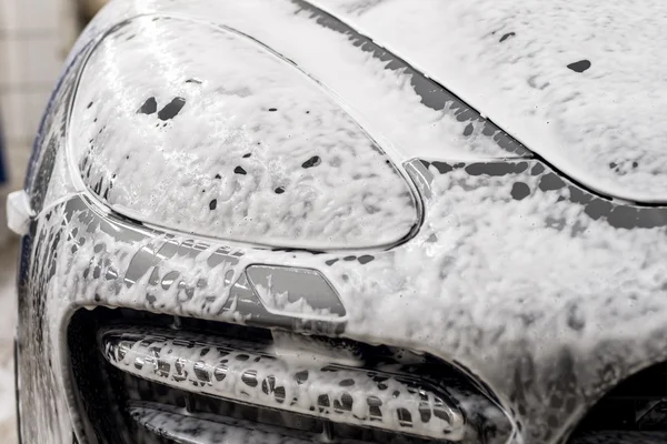 Lavado de coches. Auto cubierto de espuma . — Foto de Stock