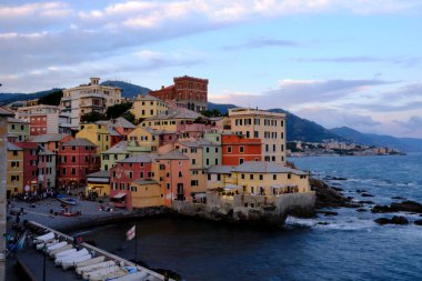 Boccadasse sahilinin renkli evleri ve arkasında yumuşak dalgalar olan uzun pozlu bir fotoğrafı. Cenova, Ligurie, İtalya