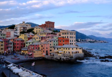 Boccadasse sahilinin renkli evleri ve arkasında yumuşak dalgalar olan uzun pozlu bir fotoğrafı. Cenova, Ligurie, İtalya