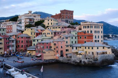 Boccadasse sahilinin renkli evleri ve arkasında yumuşak dalgalar olan uzun pozlu bir fotoğrafı. Cenova, Ligurie, İtalya