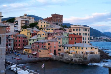 Boccadasse sahilinin renkli evleri ve arkasında yumuşak dalgalar olan uzun pozlu bir fotoğrafı. Cenova, Ligurie, İtalya