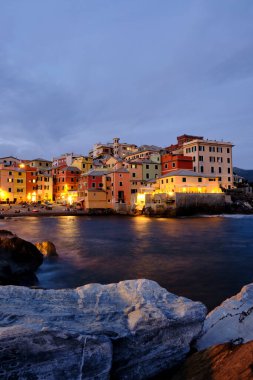 Boccadasse sahilinin renkli evleri ve arkasında yumuşak dalgalar olan uzun pozlu bir fotoğrafı. Cenova, Ligurie, İtalya