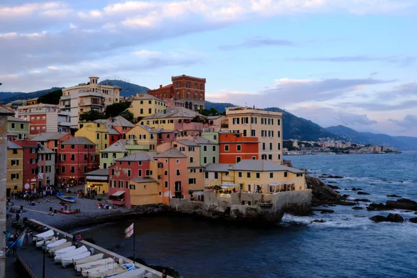 Boccadasse sahilinin renkli evleri ve arkasında yumuşak dalgalar olan uzun pozlu bir fotoğrafı. Cenova, Ligurie, İtalya