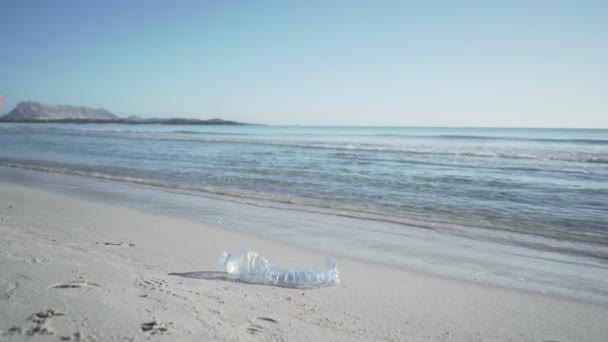 照顾好大自然和周围环境 一个年轻而负责任的女士在日落或黎明时分在海滨散步 捡起一个被一个举止粗鲁的人丢弃在海里的塑料瓶 — 图库视频影像