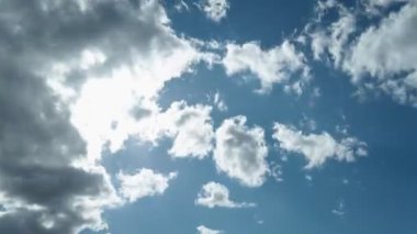 4k UHD zaman kavramı güneşin 50 saniyeden daha uzun bir sürede mavi gökyüzünü baştan aşağı geçerek beyaz bulutların hızla yükselmesiyle kaybolana kadar devam eder.