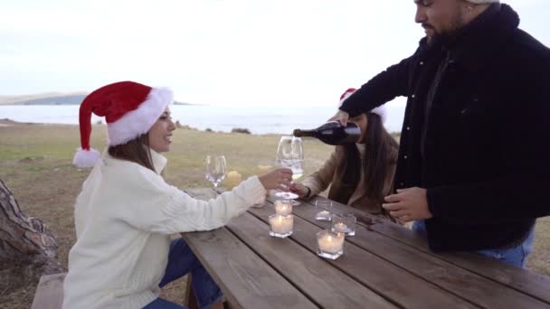 Slow Motion Mixed Race Young People Table Outdoors Santa Hats — Stock Video