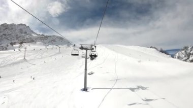 4K UHD, Courmayeur 'daki Mont Blanc' ın yamaçlarında kayakçıları uçuran bir asansör tarafından çekildi - Alp dağlarında kış tatili, kar manzaralı kayak yapmak.