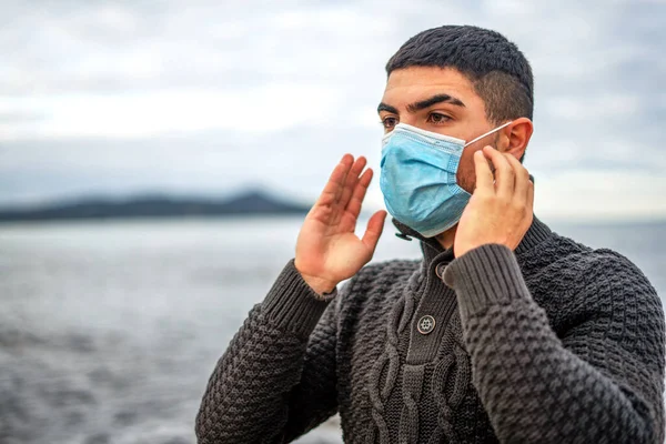 어두운 스웨터를 해변에 잘생긴 남자가 코로나 바이러스 코로나 바이러스 의학적 — 스톡 사진