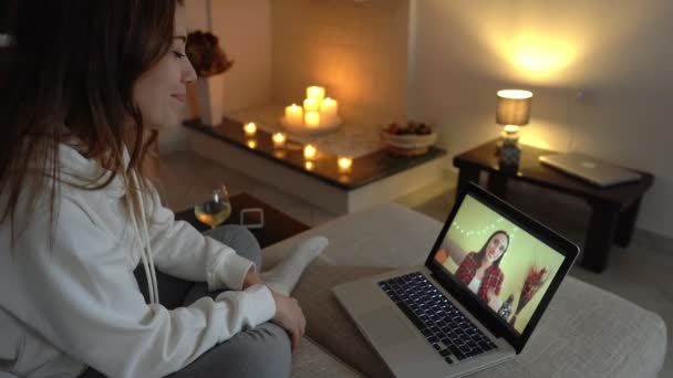 年轻女子在笔记本电脑上观看她最好的朋友在视频会议技术 用酒杯烤葡萄酒的视频通过手机视频通话与远方的朋友保持联系和庆祝 — 图库视频影像
