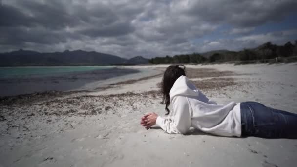 Oigenkännlig Ung Kvinna Ligger Ensam Havet Stranden Vintern Klä Casual — Stockvideo