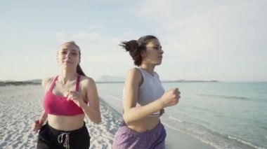 Gün batımında tropikal bir plajda saçları birbirine bağlı iki tatlı kızın günbatımında formda ve eğitimli kalmaları için ağır çekimde oynamaları. Yeni Z jenerasyonu daha iyi bir yaşam için sağlıklı yaşam ile uğraşır.