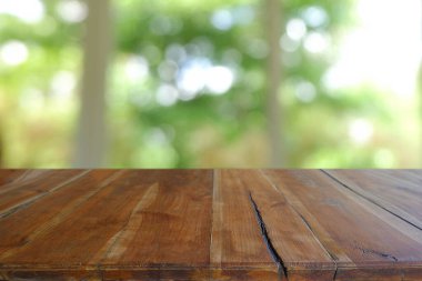 Soyut bulanık kafenin önündeki boş ahşap masa, geceleri restoran. Montaj ürünü görüntüleme veya tasarım için anahtar görsel düzeni - Resim