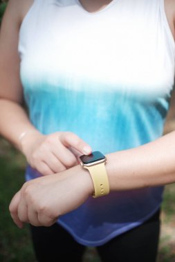 Sporcuların eli, spor yaparken akıllı saate dokunur.