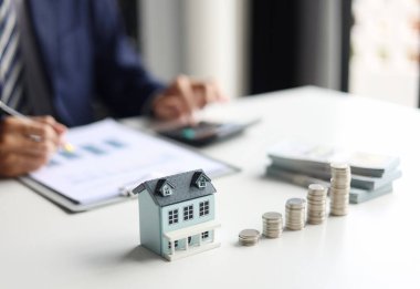 Emlakçı ya da yatırımcı, emlak yatırımları için finansal verileri hesaplıyor, planlıyor ve analiz ediyor. Tasarruf, yatırım, ev satın almanın finansal yönleri.