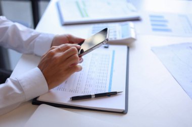 Ofiste çalışan iş adamı akıllı telefon kullanıyor.. 