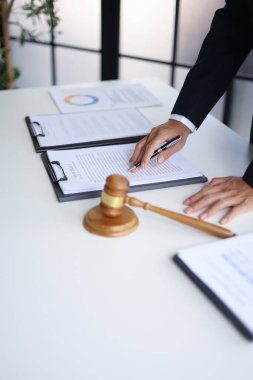 Yasal danışman yasal bir anlaşmayı sonuçlandırmak için sözleşme belgelerini okuyor. Hukuki danışmanlık ve yargı yetkisi kavramları.