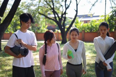 Bir grup arkadaş egzersizden sonra parkta birlikte yürüyorlar..