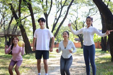 Bir grup arkadaş parkta eğleniyor, zıplıyor, top oynuyor..