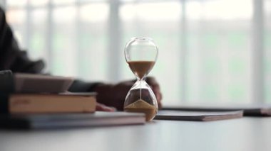 Kum saatlerine odaklan. Ofis masasında çalışan bir iş adamı. Zaman yönetimi kavramı.